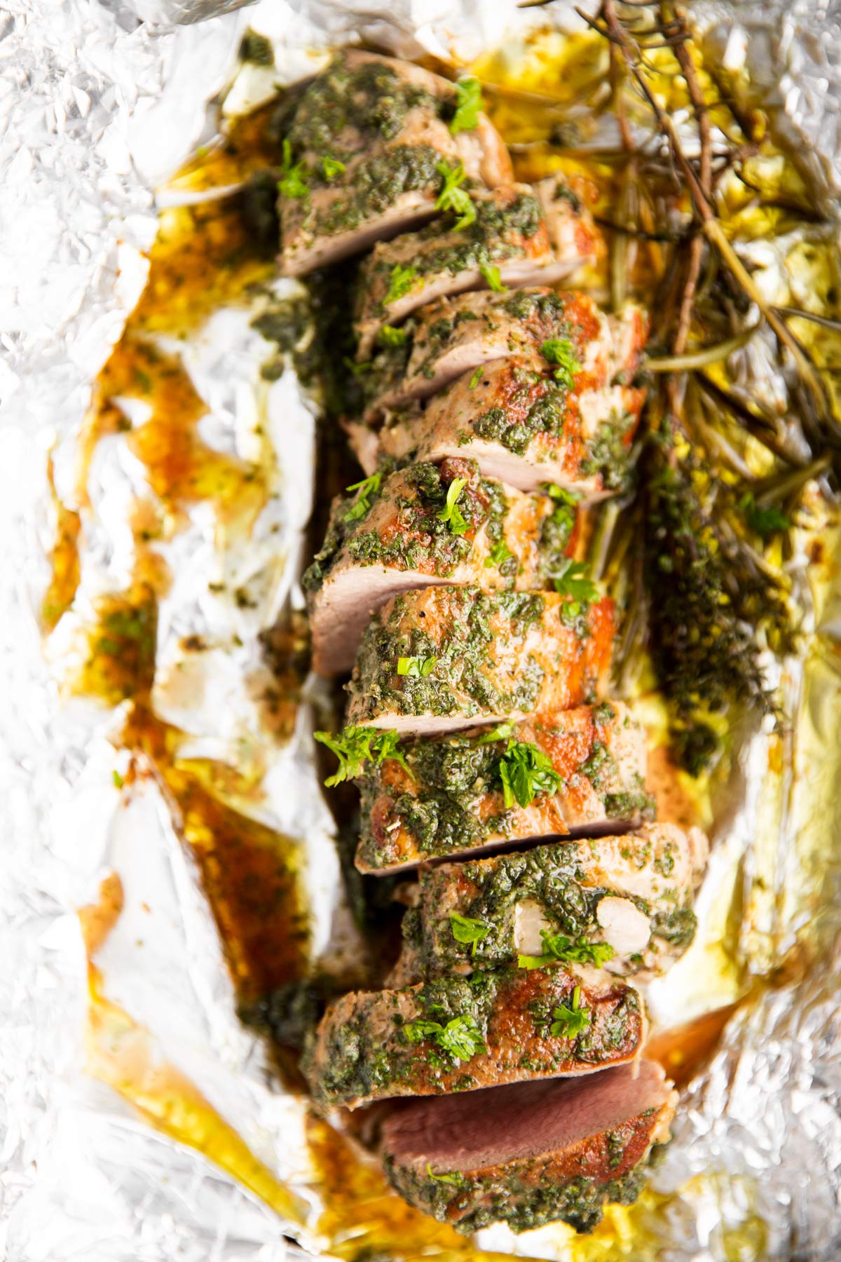 sliced roasted pork tenderloin on aluminum foil