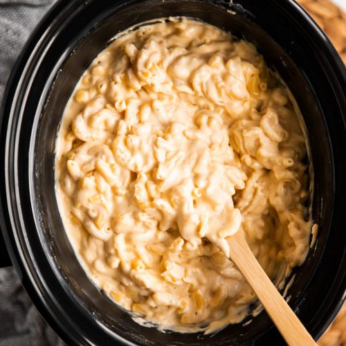 overhead view on crockpot with Mac and cheese and wooden spoon