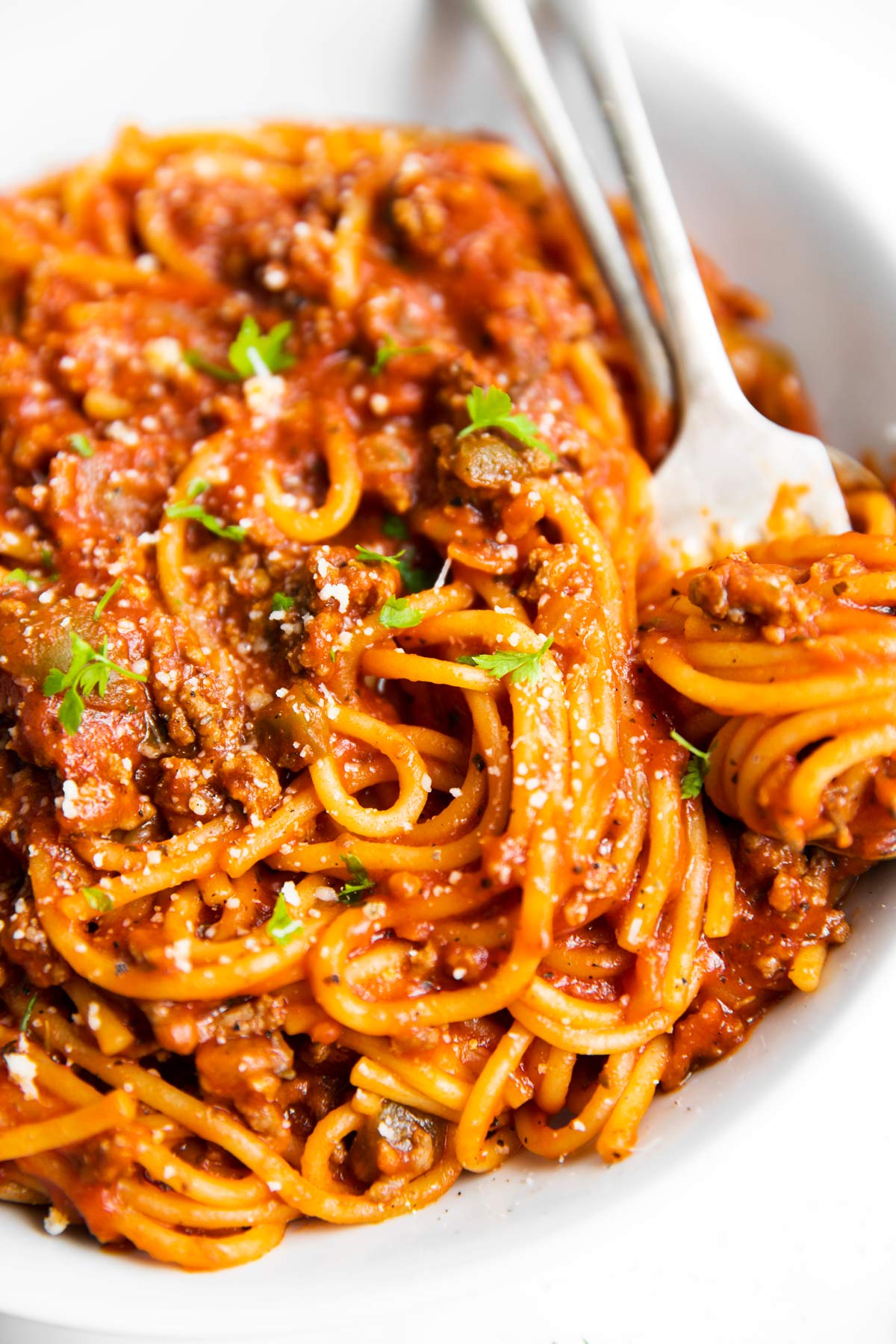 white plate with spaghetti and meat sauce