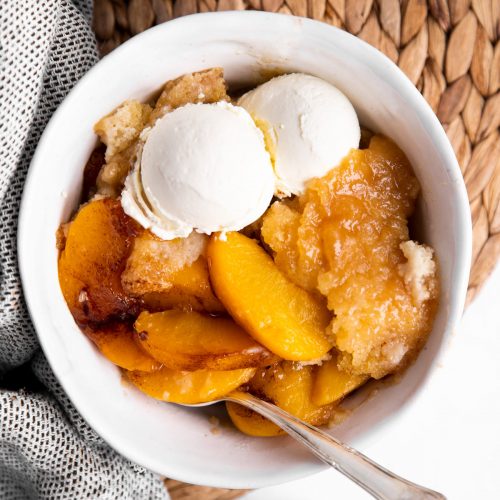 overhead view of a bowl with peach cobbler