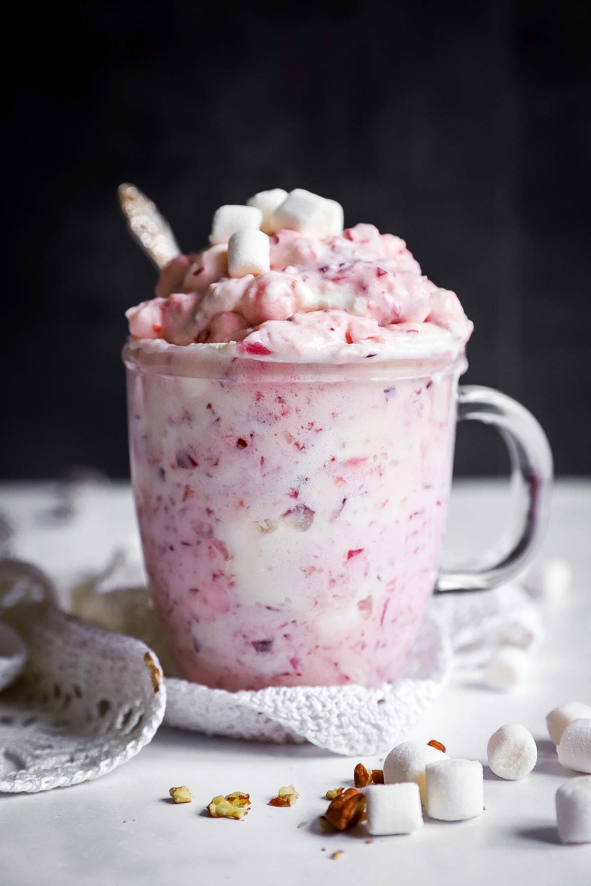 glass mug with cranberry fluff salad in front of dark background