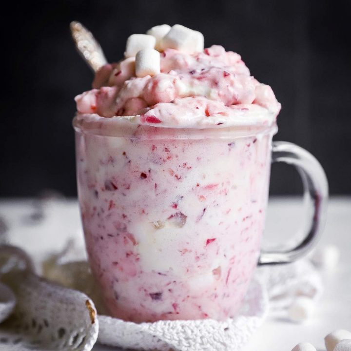 glass mug with cranberry fluff salad in front of dark background