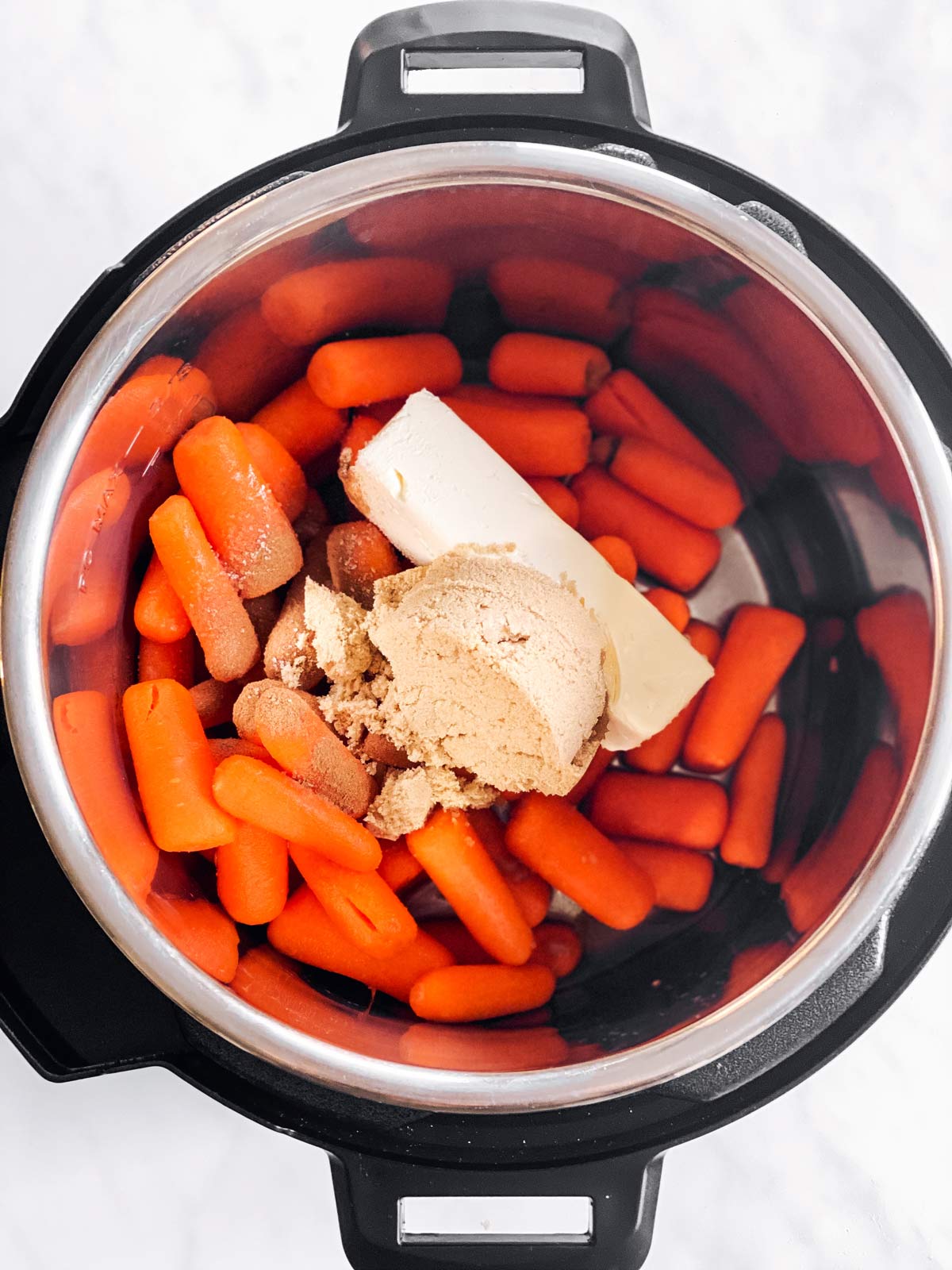 instant pot with ingredients for glazed carrots