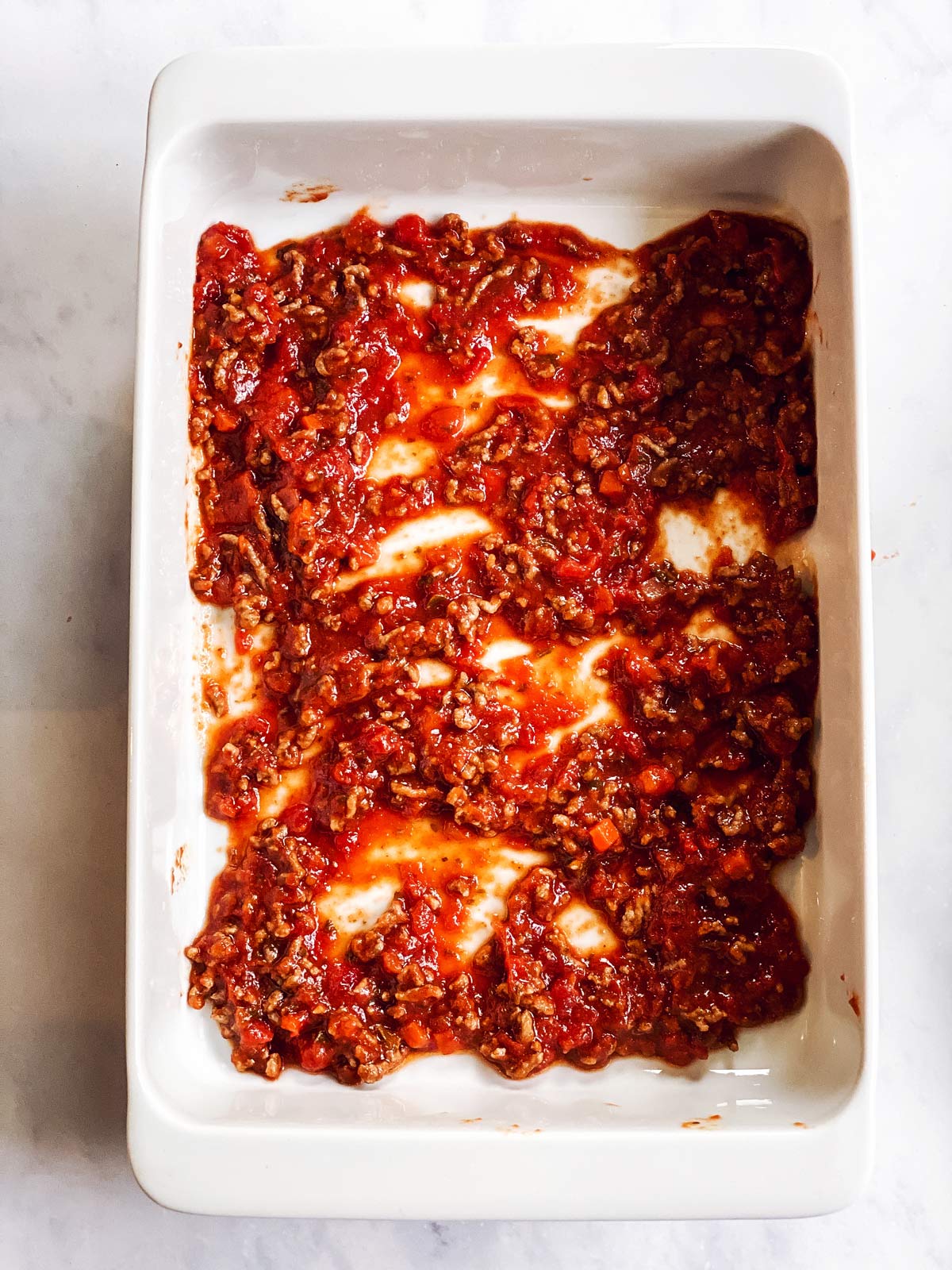 meat sauce in white casserole dish