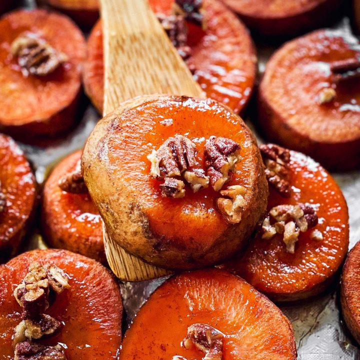 close up of wooden spatula with baked sweet potato slice on top