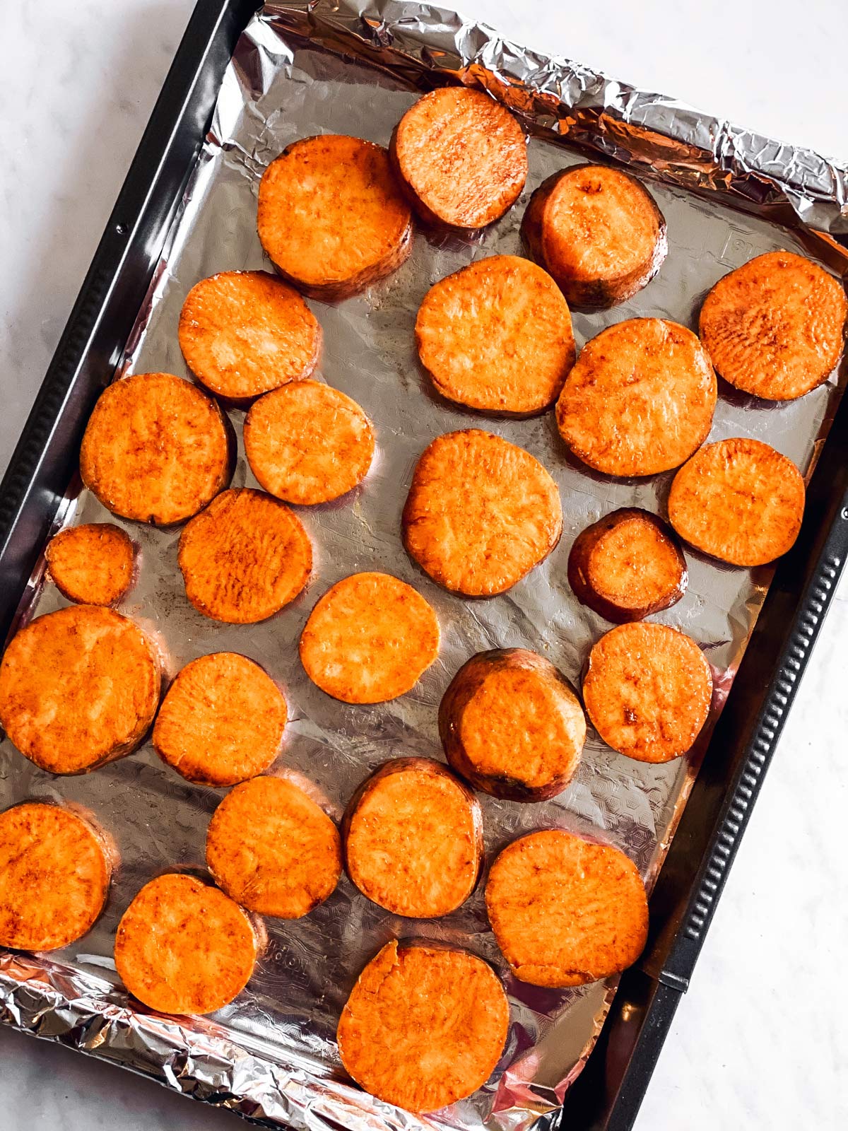 baking sheet with raw sweet potato slices