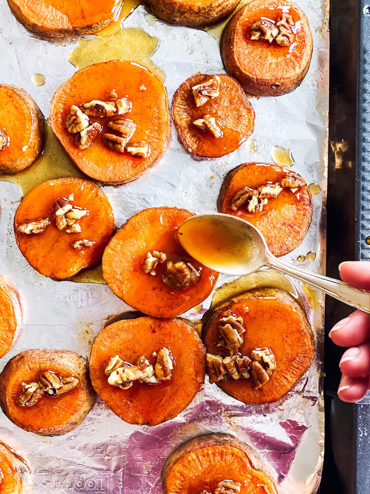 spooning glaze on baked sweet potato slices