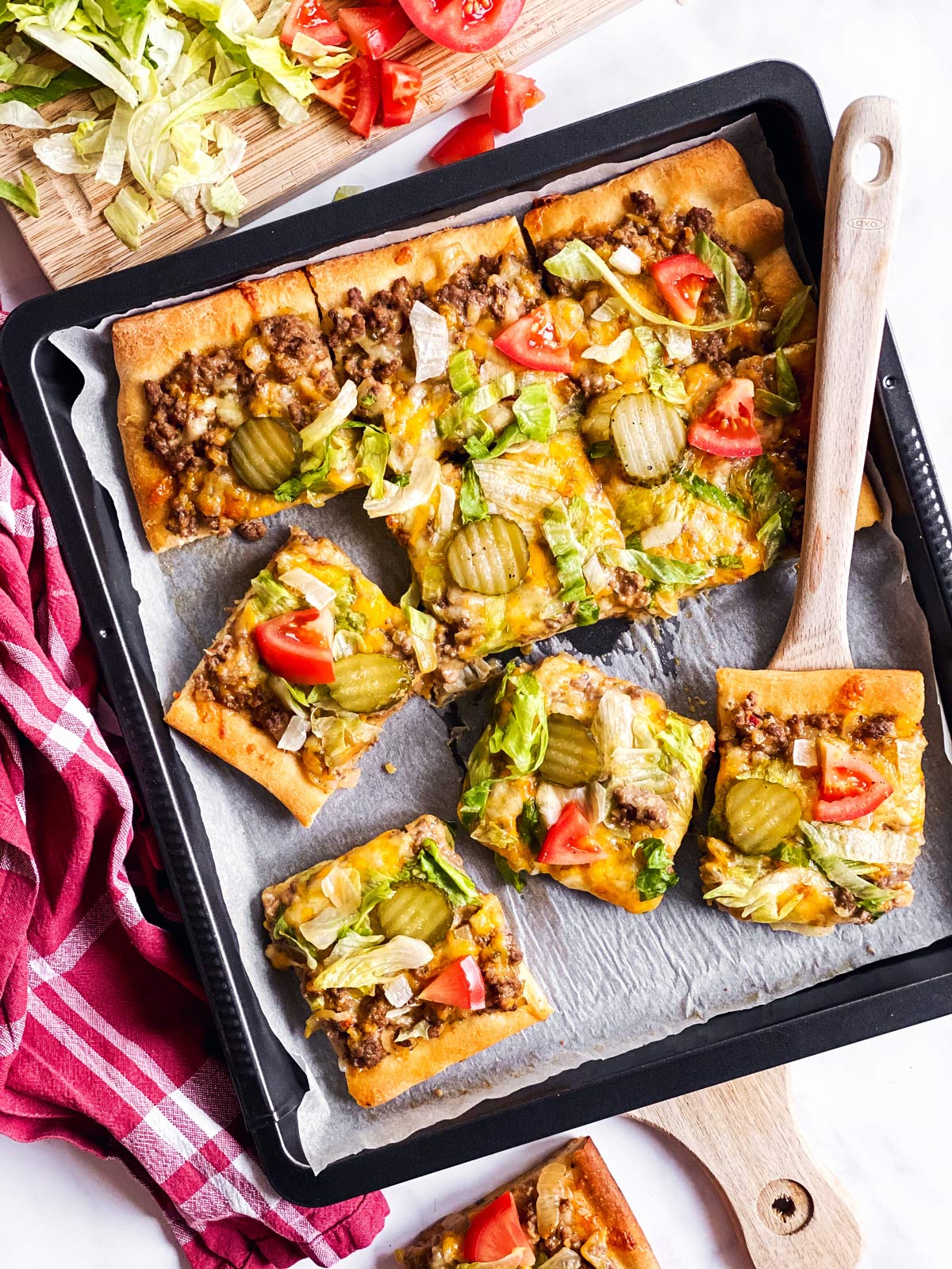 overhead view of sliced Big Mac pizza on dark pan