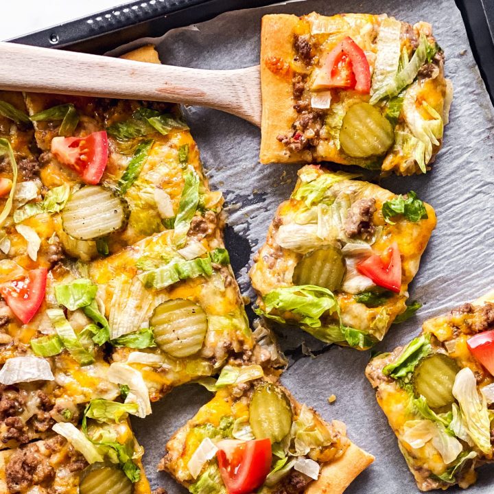 overhead view of sliced Big Mac pizza on dark pan