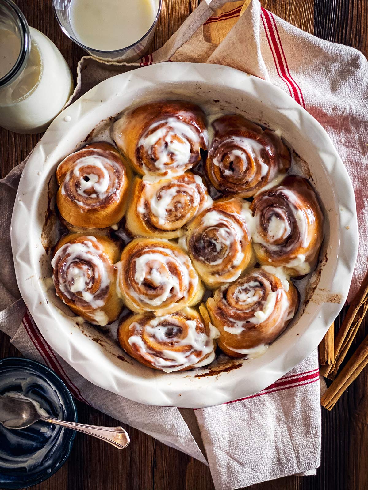 round pan with baked cinnamon rolls on wooden surface