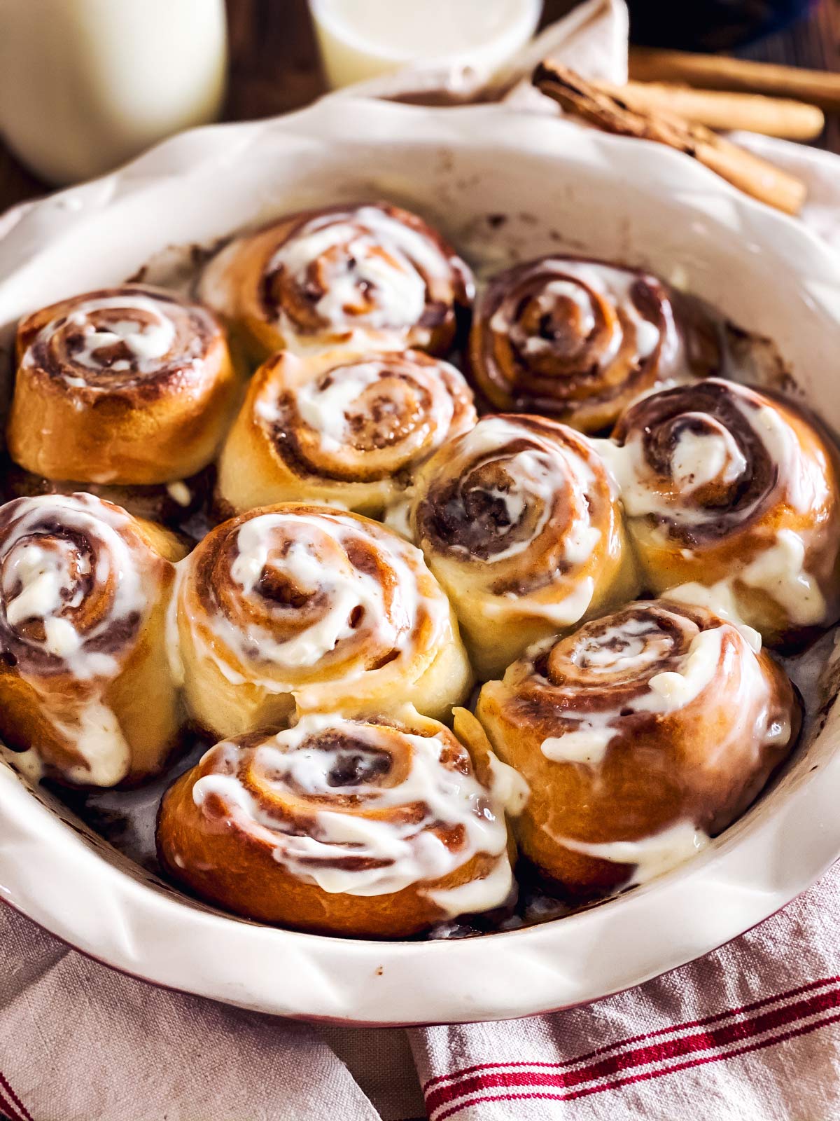 pan with cinnamon rolls in front of milk bottle