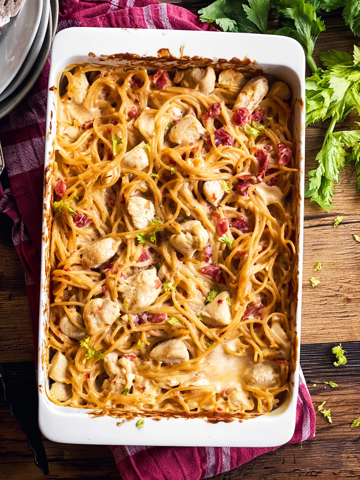 white casserole dish with chicken spaghetti on wooden background