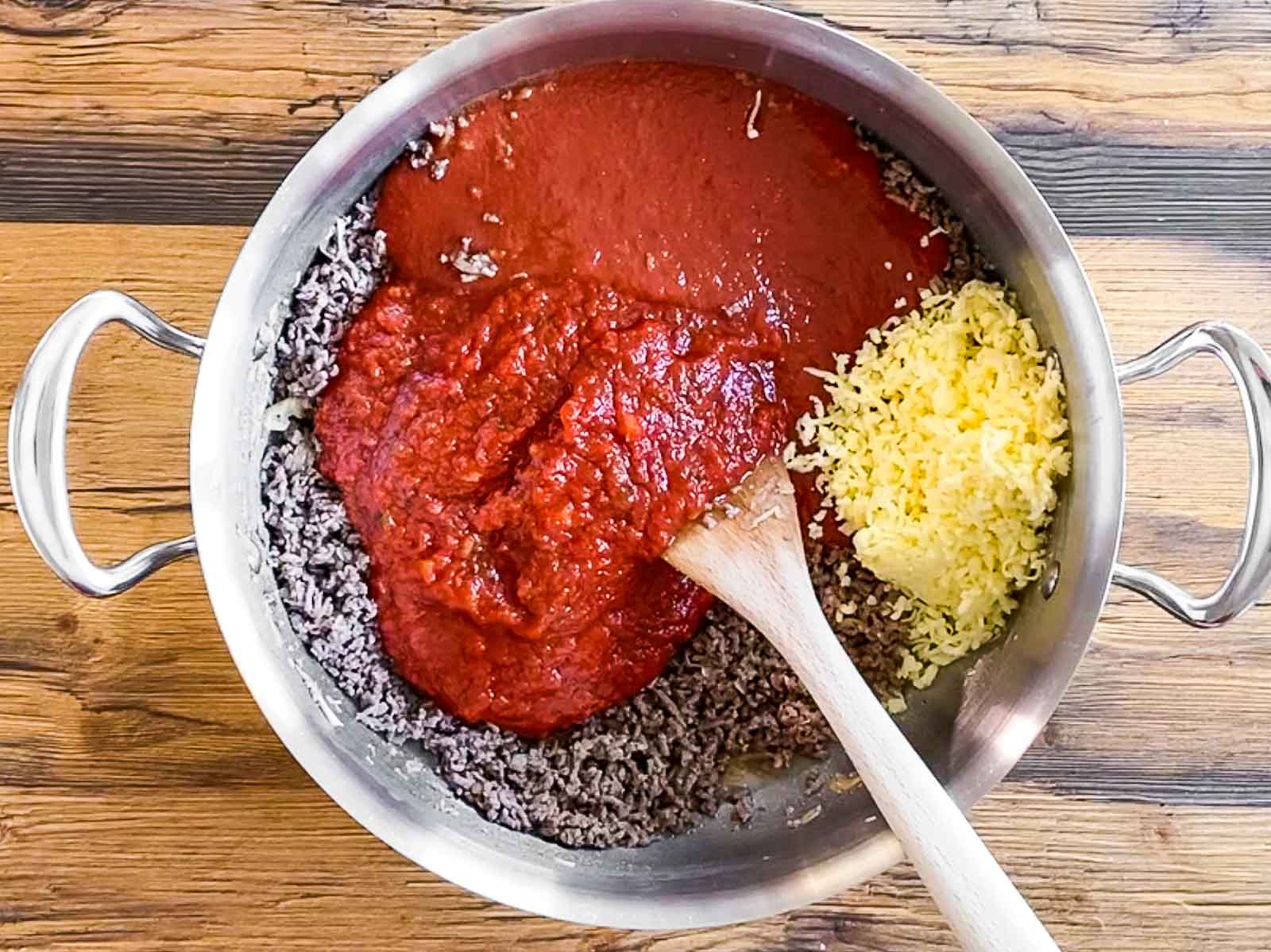 browned beef with tomato sauce and cheese in skillet