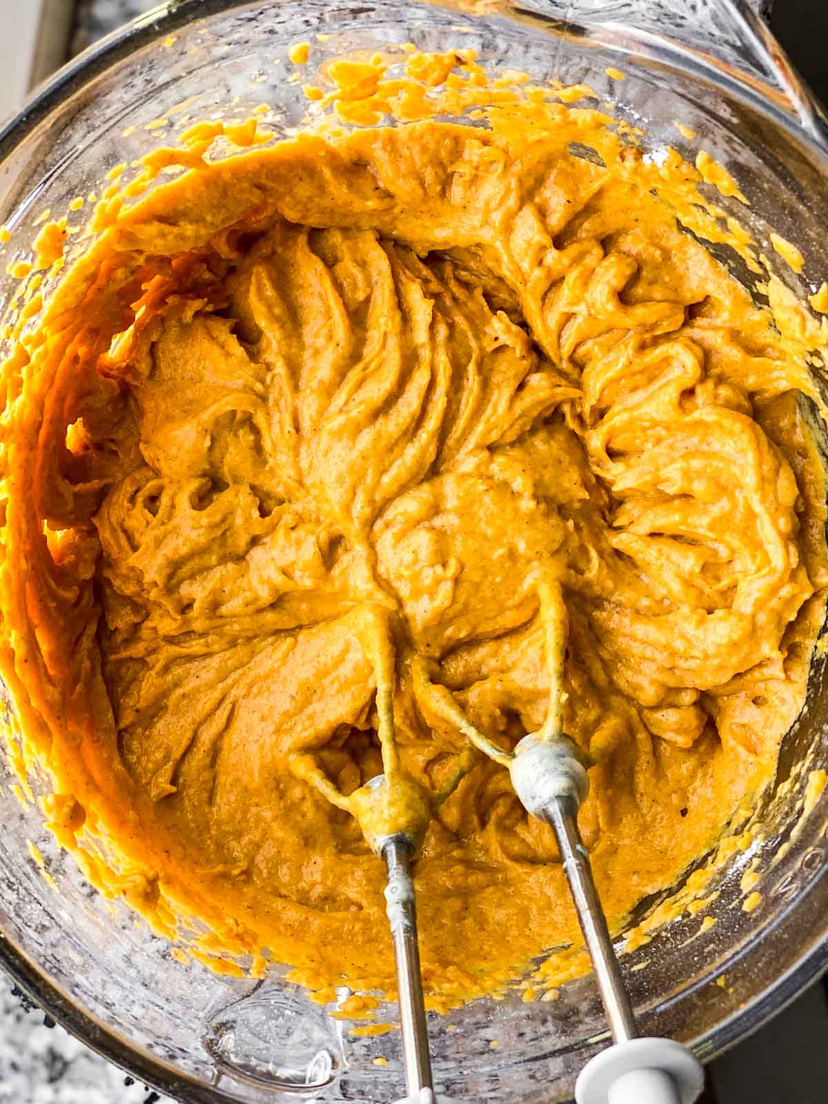 batter for cake mix pumpkin muffins in glass bowl with beaters