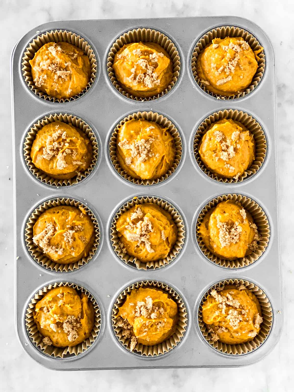 muffin pan filled with batter for pumpkin muffins