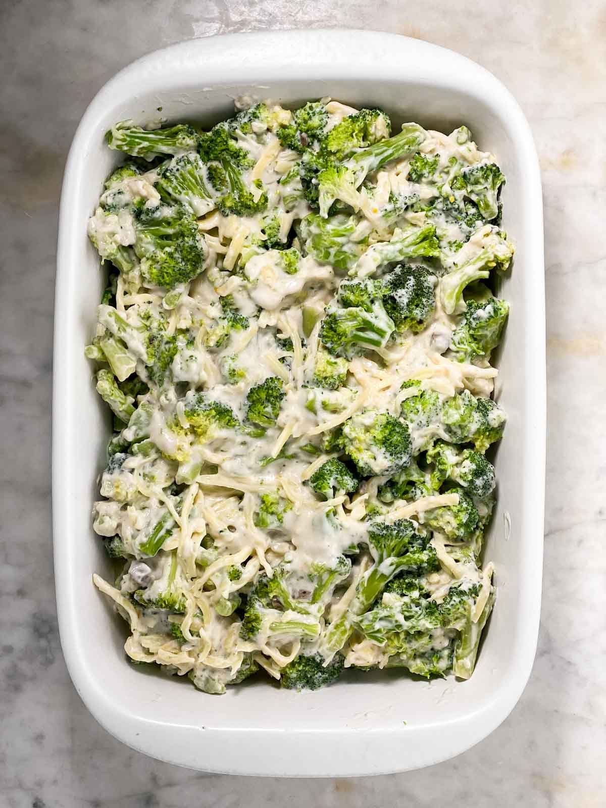 broccoli casserole filling spread in white casserole dish