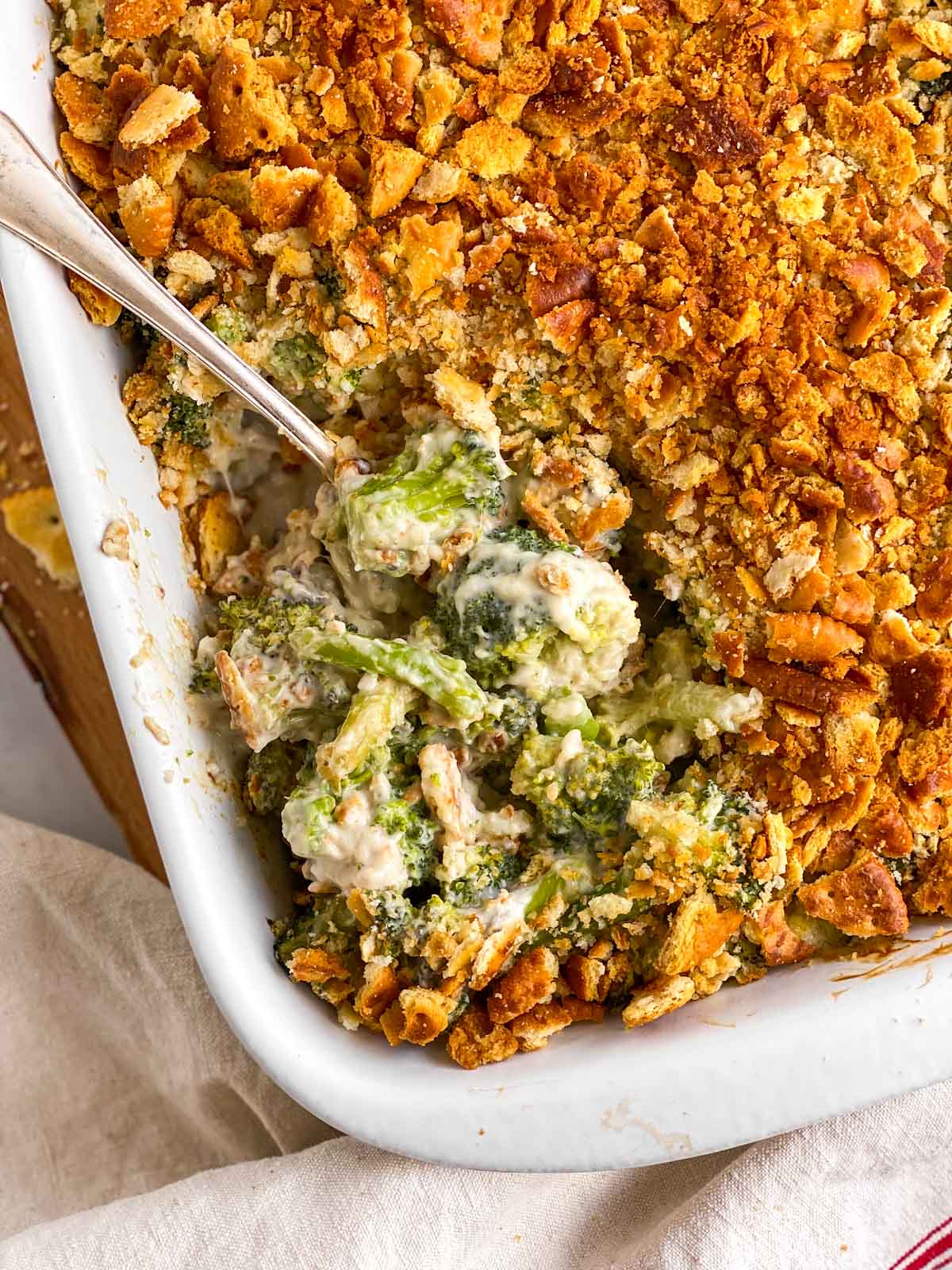 overhead view of ritz broccoli casserole in white dish with spoon stuck in