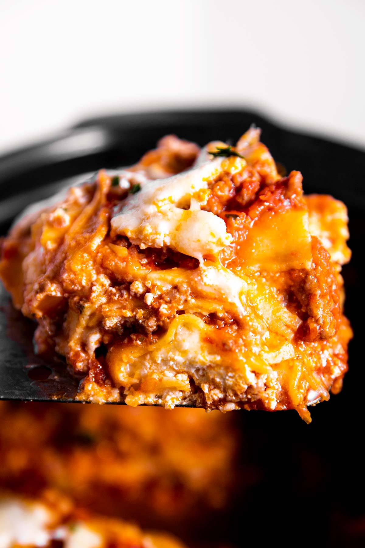 close up photo of lasagna scooped out of crockpot on serving slide