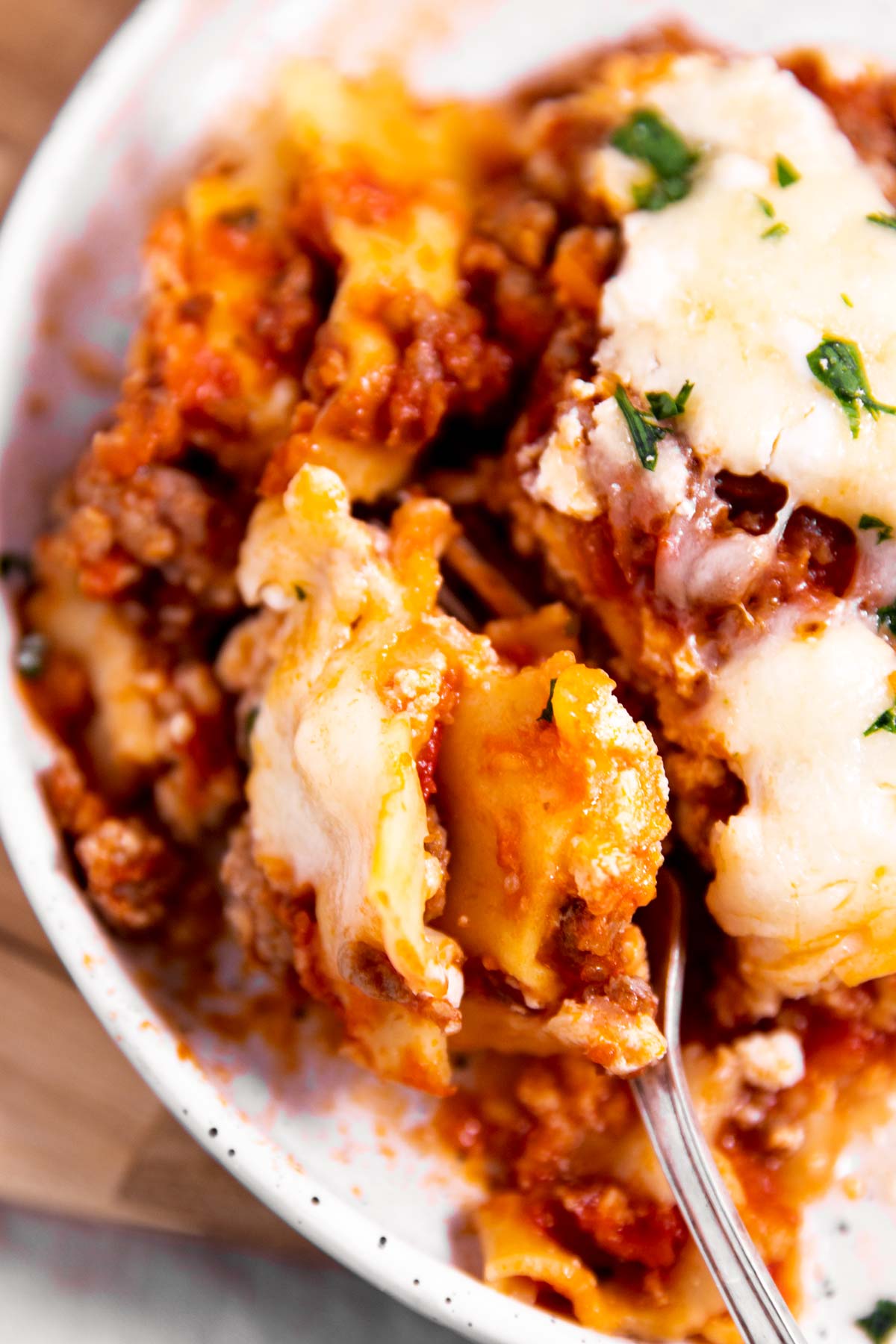 overhead view of fork digging into a plateful of lasagna