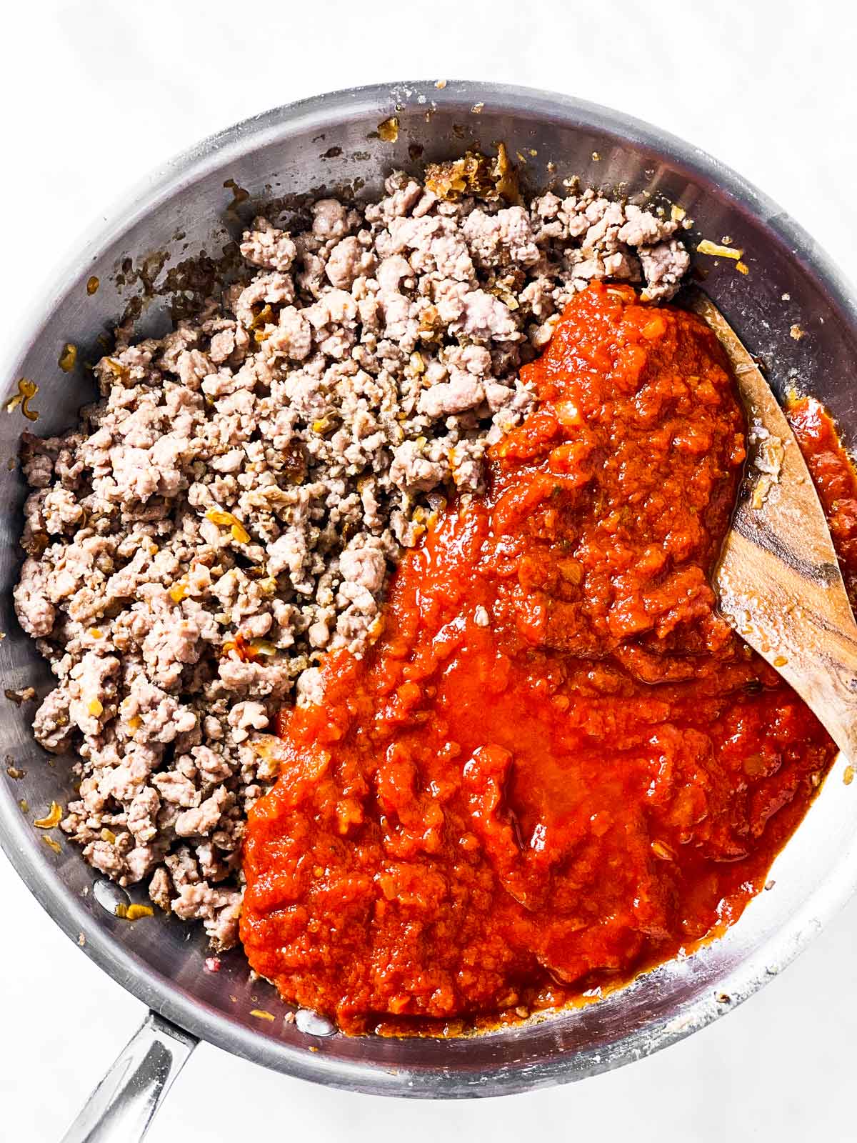 browned ground beef and spaghetti sauce in stainless steel skillet