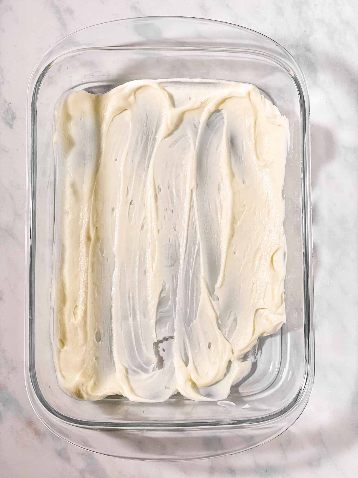 thin layer of cream cheese mixture spread over bottom of glass pan