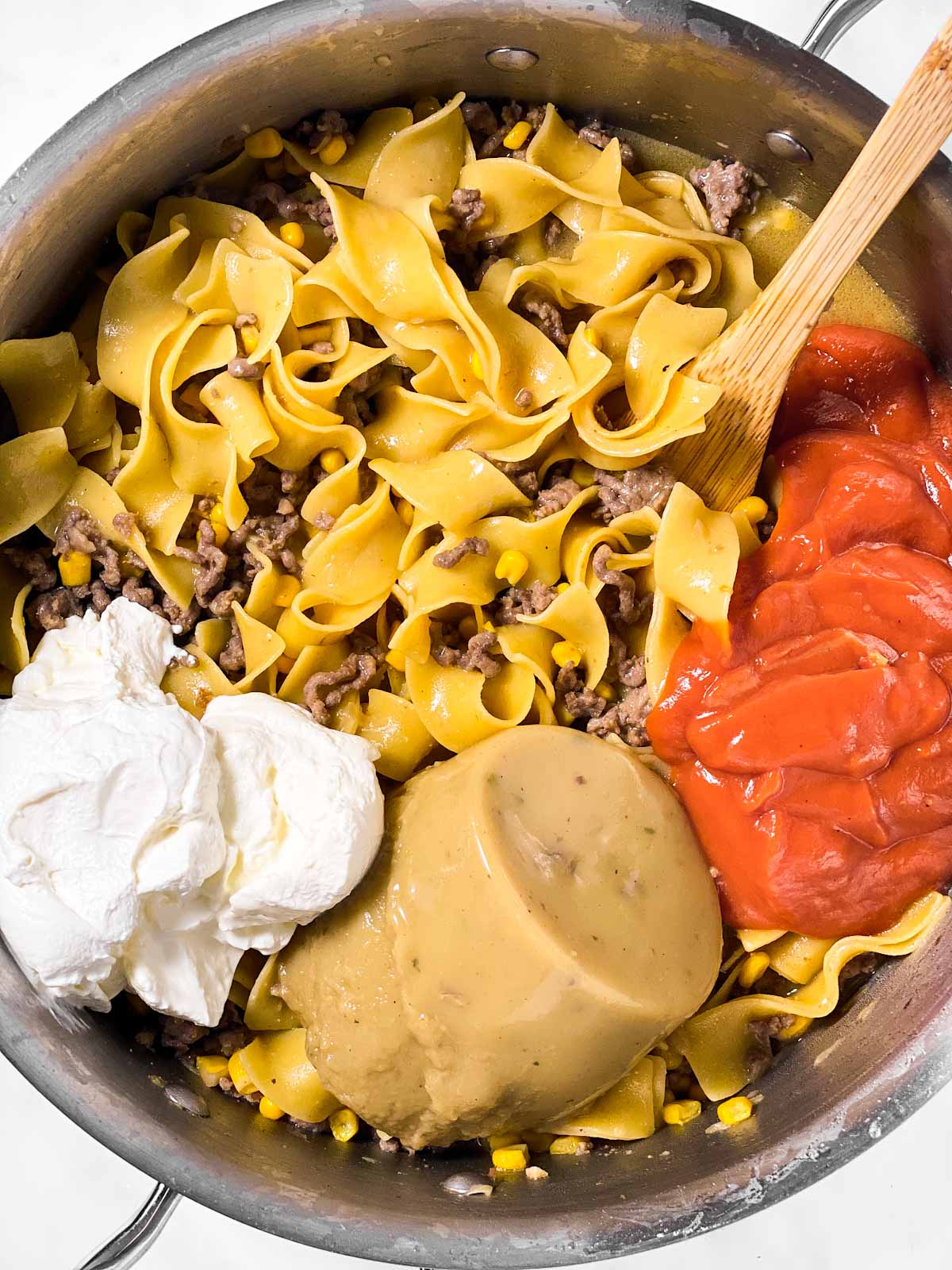 cooked noodles and beef in skillet with sour cream and canned soups