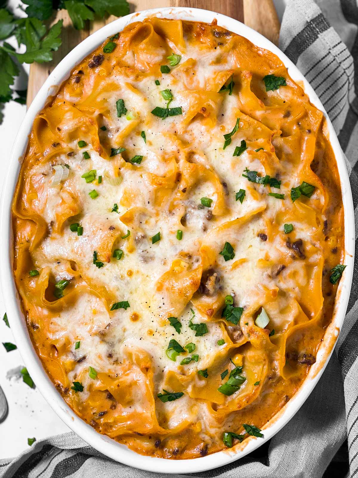 baked hamburger noodle casserole in white oval casserole dish