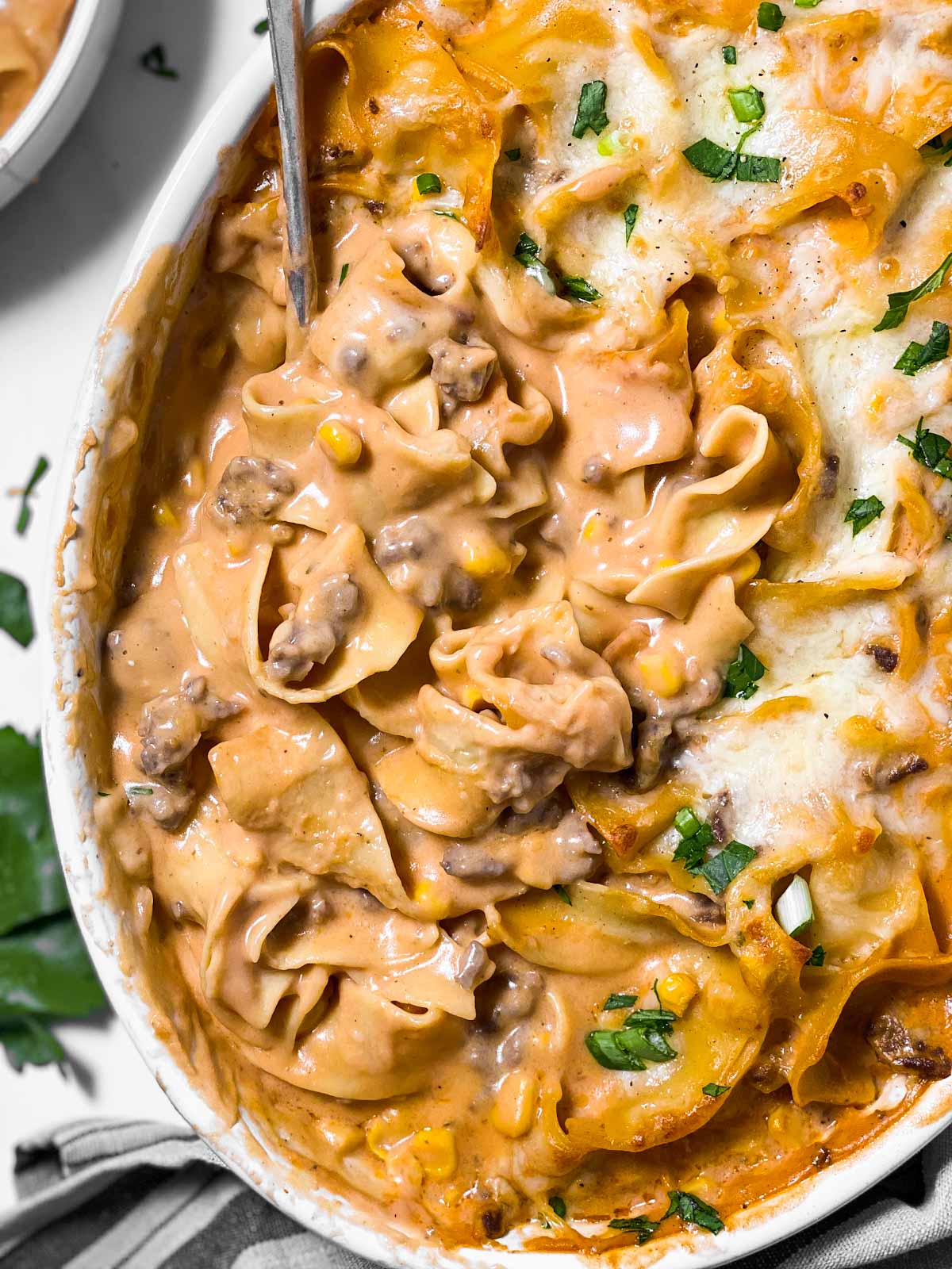 close up overhead view of spoon digging into hamburger noodle casserole