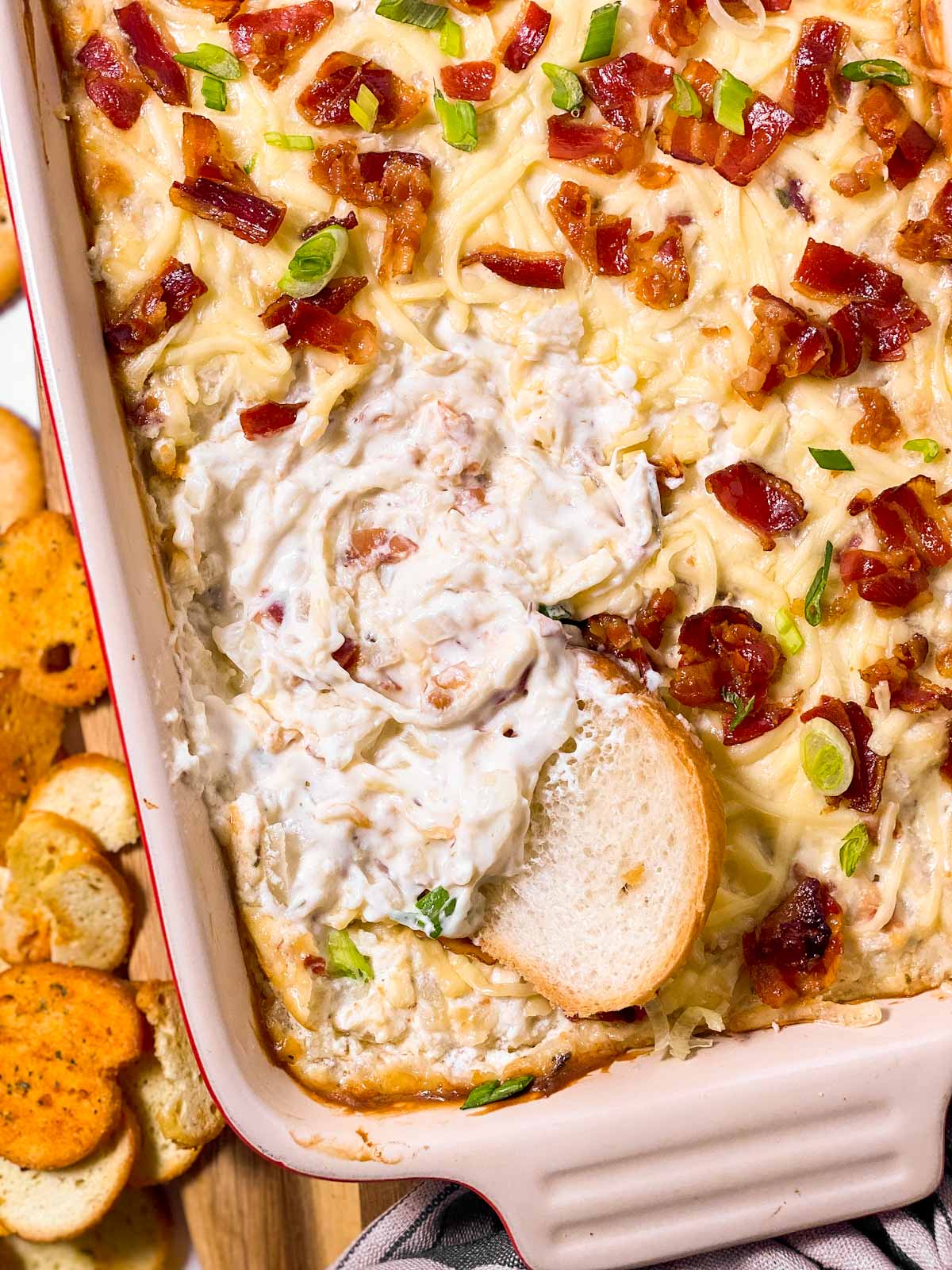 overhead view of baguette slice in dish with hot onion dip