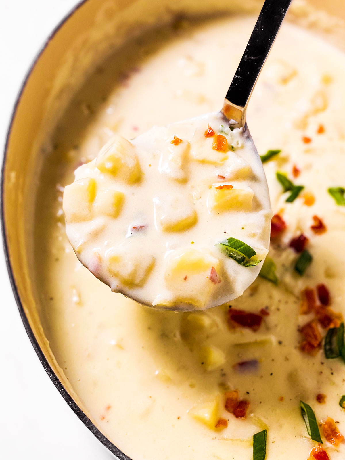 potato soup on ladle over filled pot