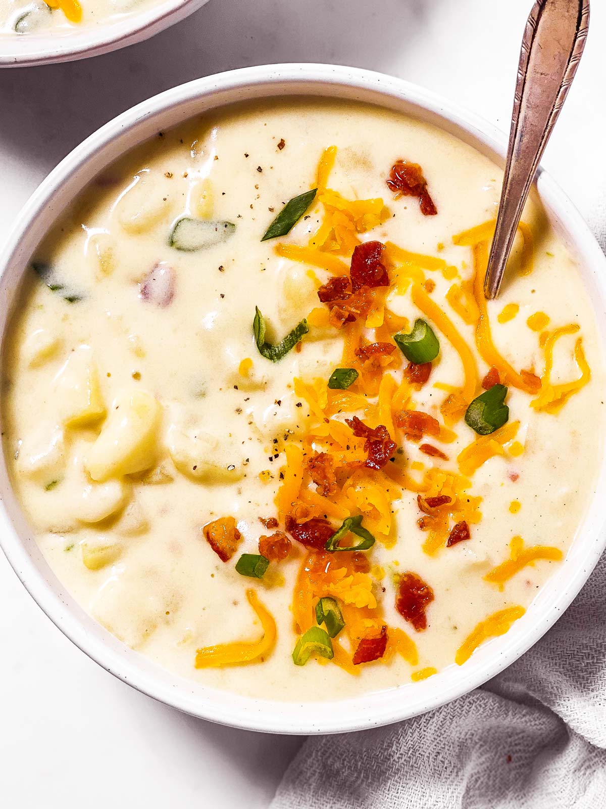 overhead close up view of white bowl filled with potato soup