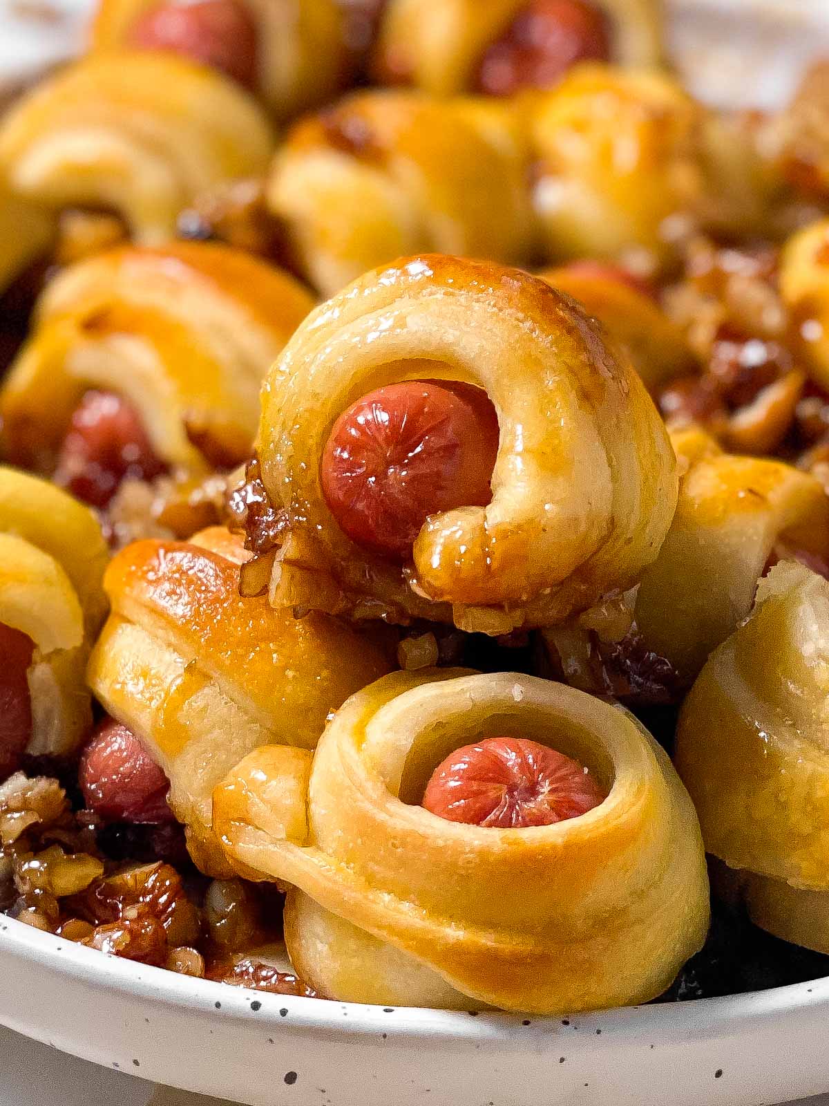 frontal close up photo of caramelized lil smokies crescent rolls