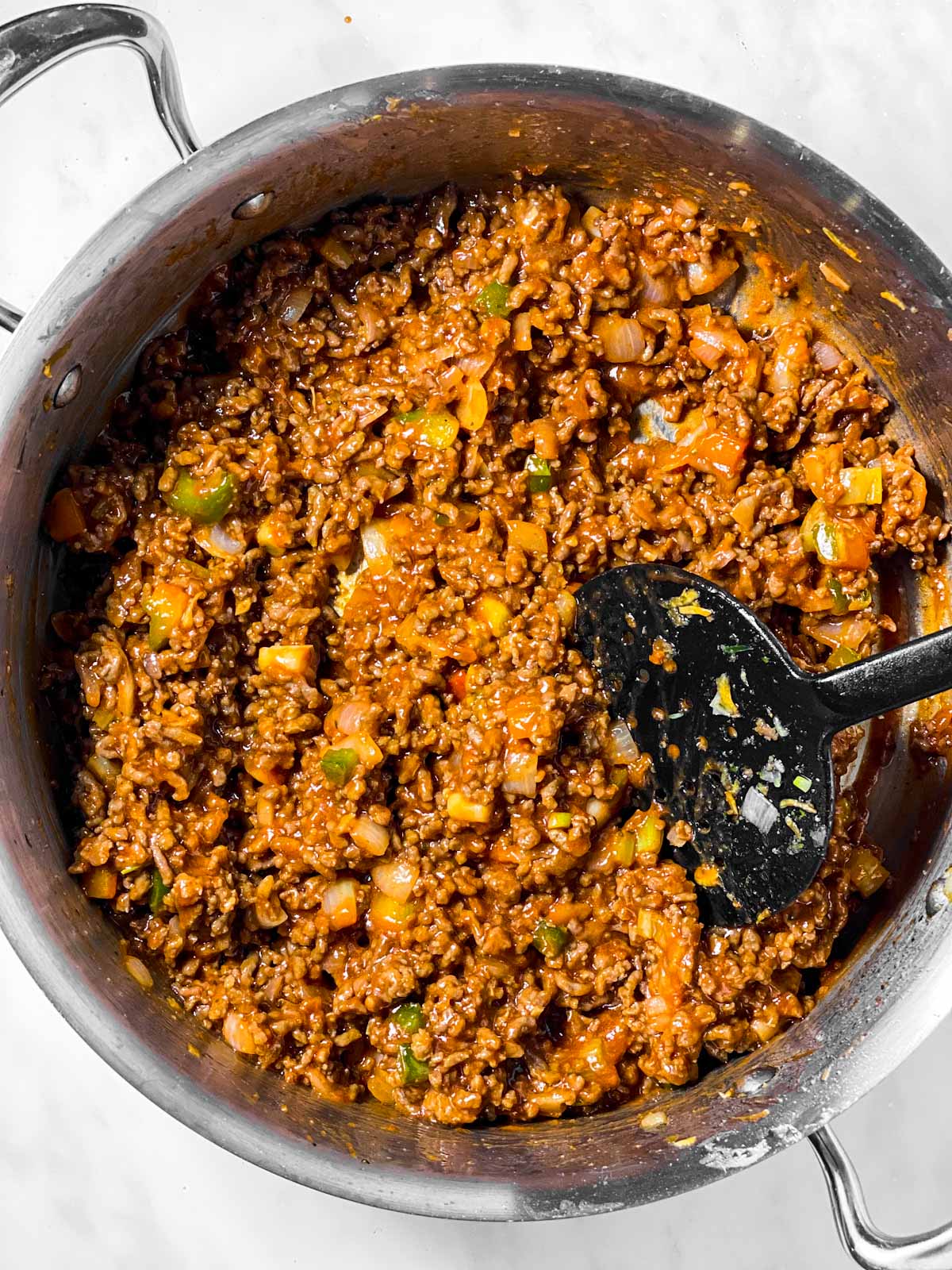 sloppy joe mixture in skillet with black cooking spoon