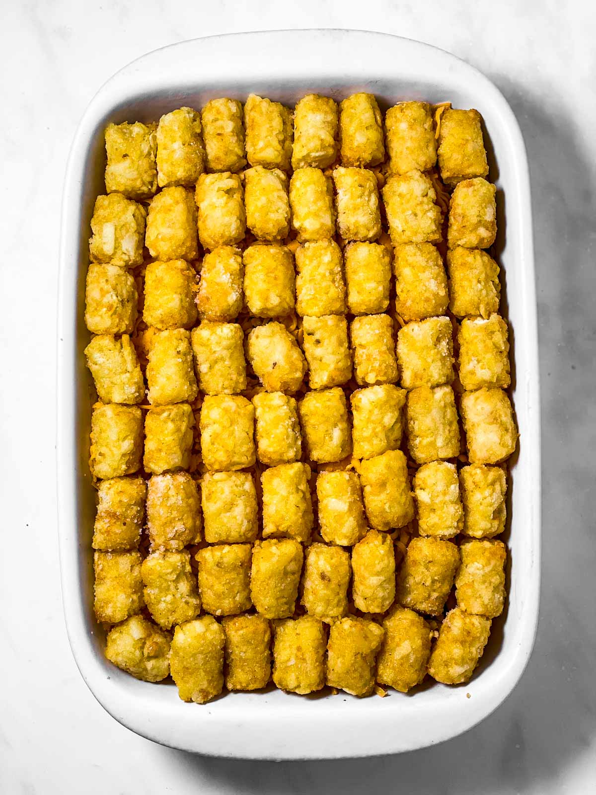 assembled tater tot casserole in white dish