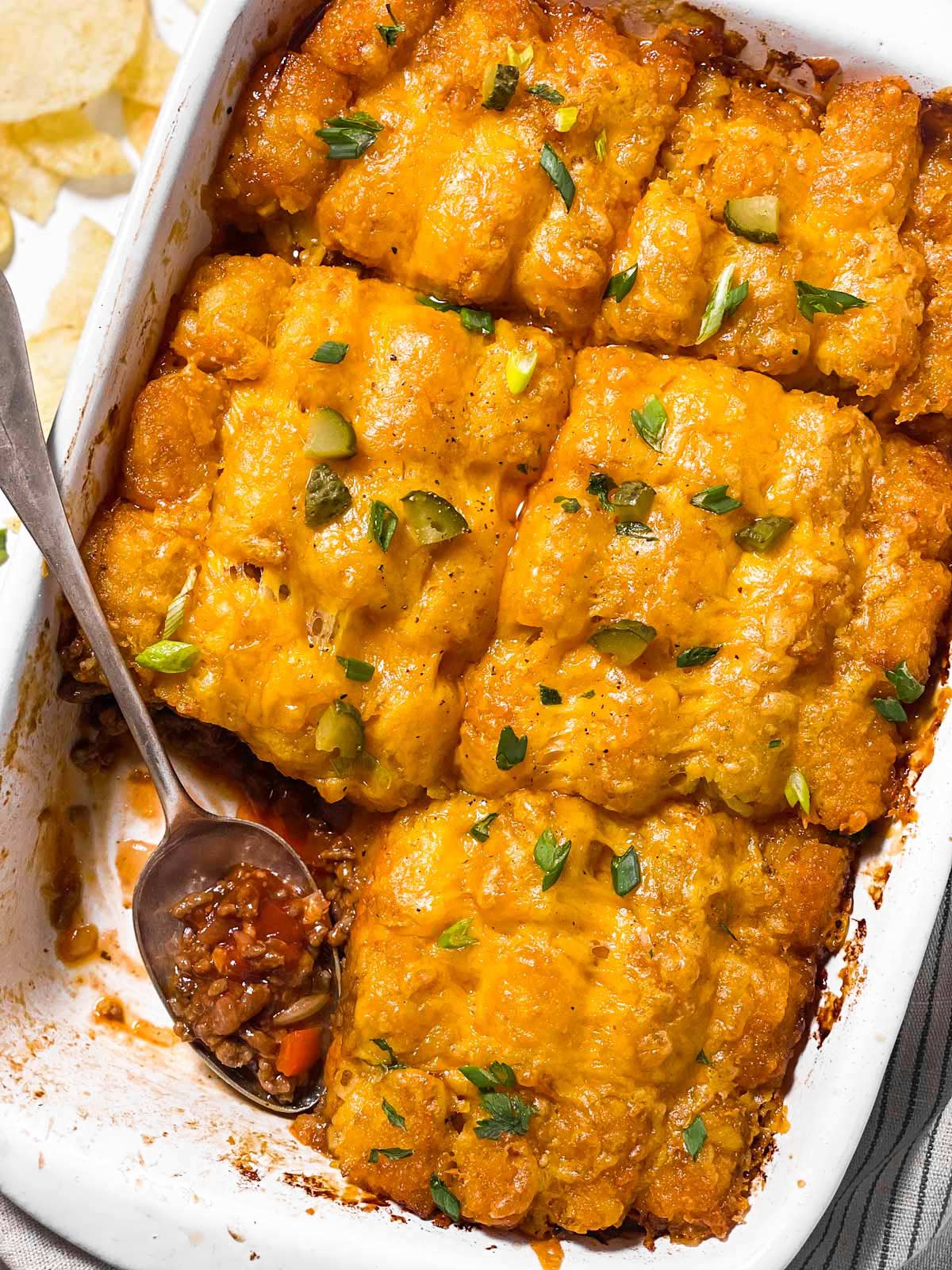 overhead view of spoon stuck in sloppy joe tater tot casserole